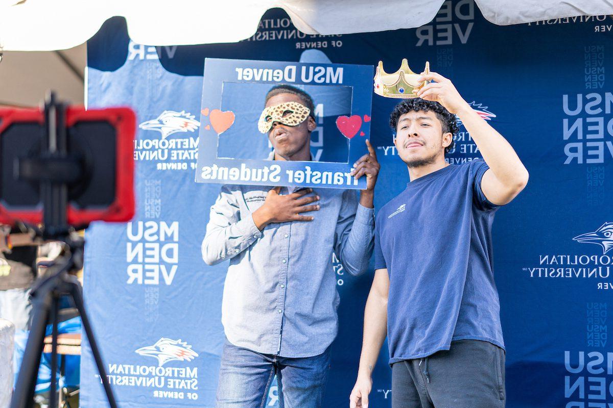 Two students making funny faces in a photo booth during the Kickoff Carnival