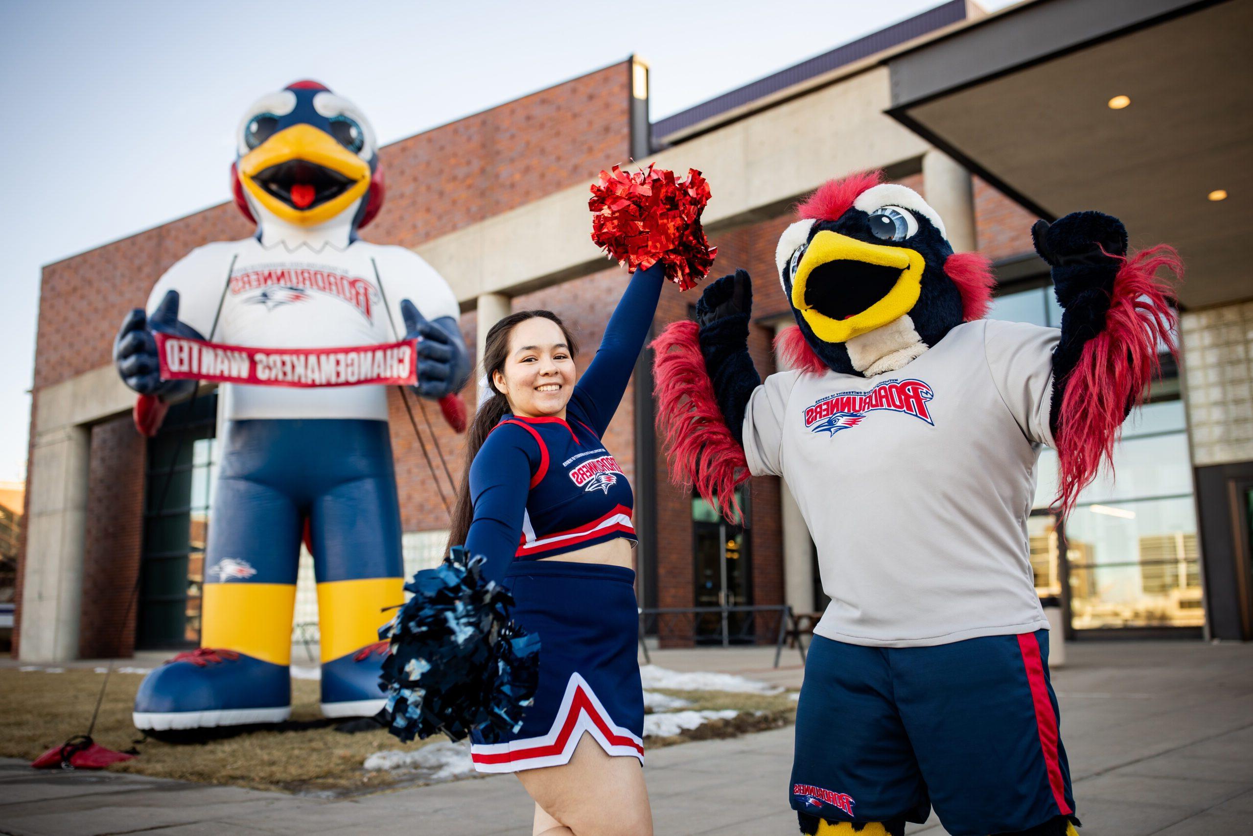 A MSU Denver cheerleader and Rowdy pose in front of a big blow-up Rowdy